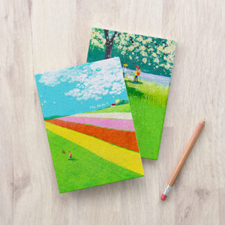 Two Love Corner Puzzle Cover notebooks on a wooden table.